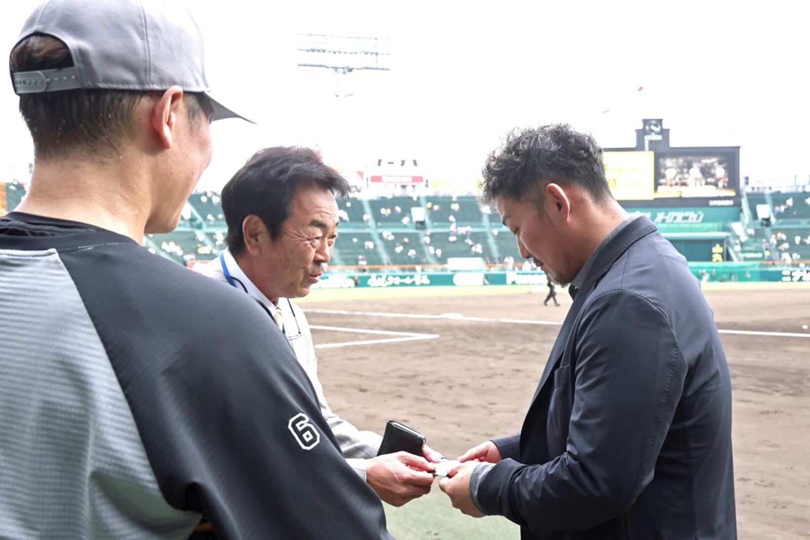 坂本勇人（手前）の目の前で水野スカウト部長と名刺交換した中田翔