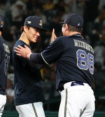 監督代行の水本勝己ヘッドコーチと喜ぶ山本由伸