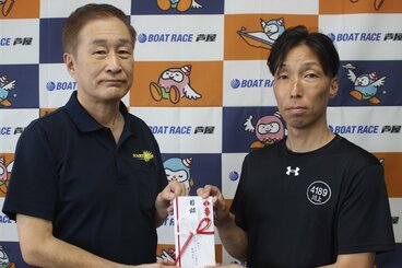 川上剛(右)が芦屋町モーターボート競走事業の藤崎隆好管理者に目録を手渡した