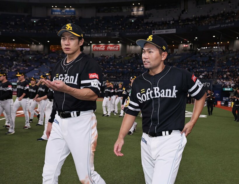 ３連覇の余韻に浸りながらグラウンドを歩く柳田悠岐（左）と中村晃
