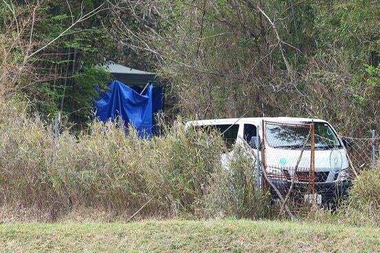 ブルーシートがかけられた現場と警察車両