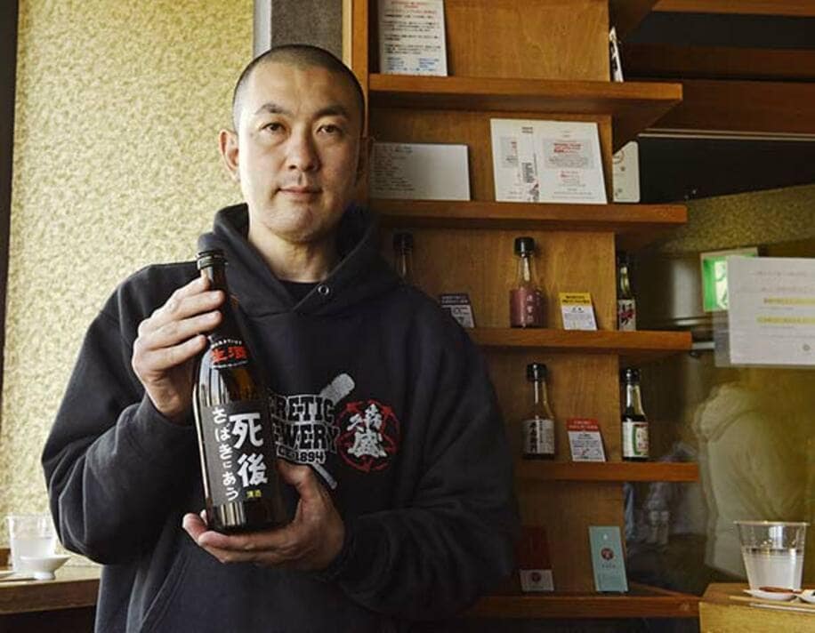  日本酒「死後さばきにあう」を持つ藤村社長