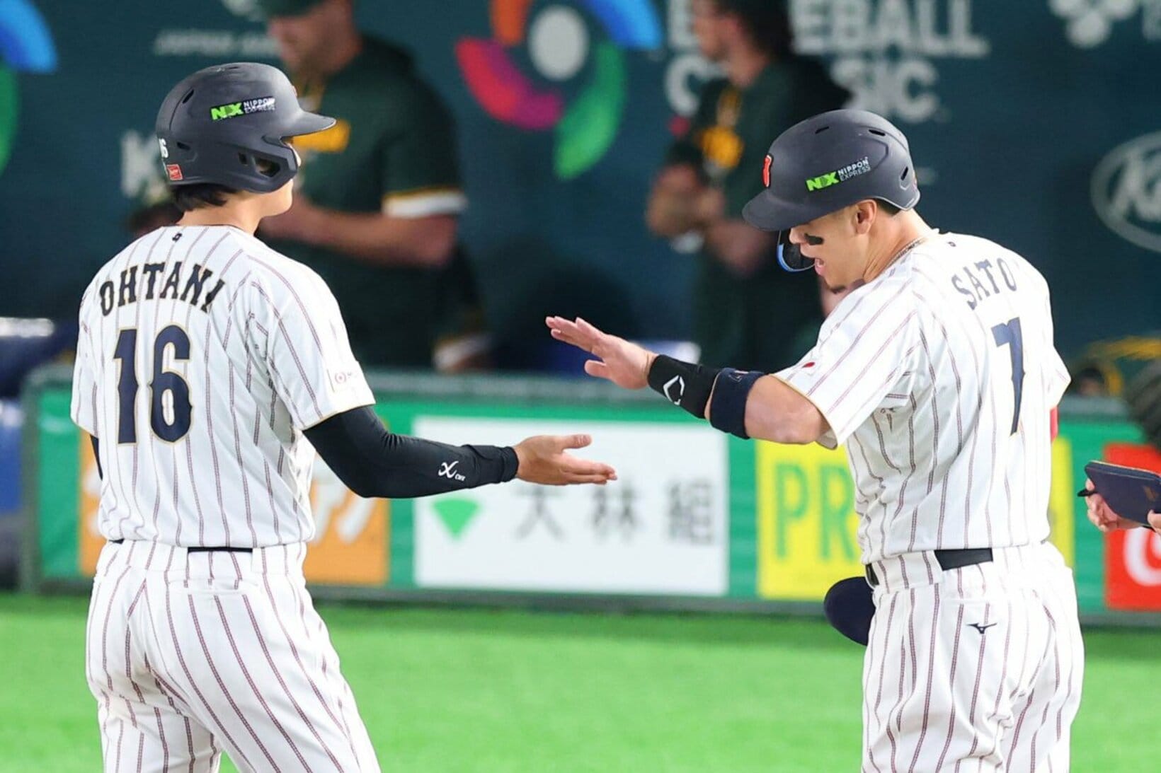 豪州戦でタイムリーを放ち大谷翔平（左）とタッチを交わす佐藤輝明