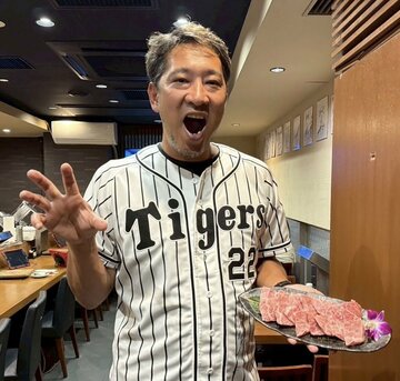藤川監督のユニホームを着ながら、肉をアピールする阪神のOB投手の加藤隆行さん