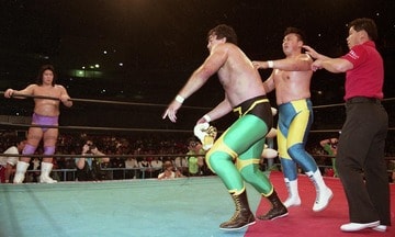 川田（右）にマスクのヒモをほどかせマスクを客席に投げ捨てる三沢（１９９０年５月、東京体育館） 
