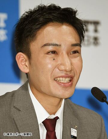  会見で笑顔を見せる桃田