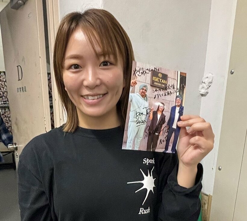 シンの襲撃被害に遭ったファンに贈ったサイン入り写真を手にするSareee(©Sareee-ISM）