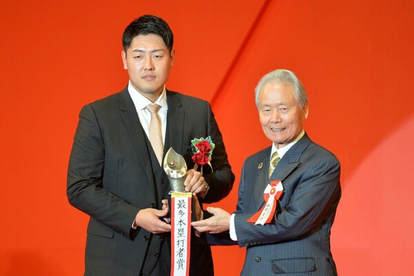 セの最多本塁打賞を獲得した巨人・岡本和真。右は榊原コミッショナー