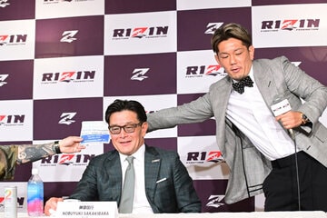 食べるステロイドを榊原信行CEO（中）越しに平本蓮に手渡す皇治（右）