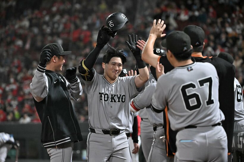 ９回、逆転２ランを放ちナインに祝福される巨人・泉口（左から２人目）