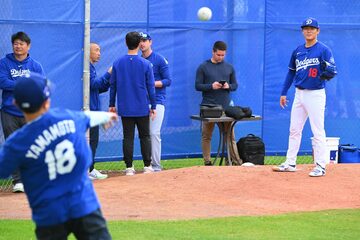 ブルペンで関係者の子供とキャッチボールする山本（右）