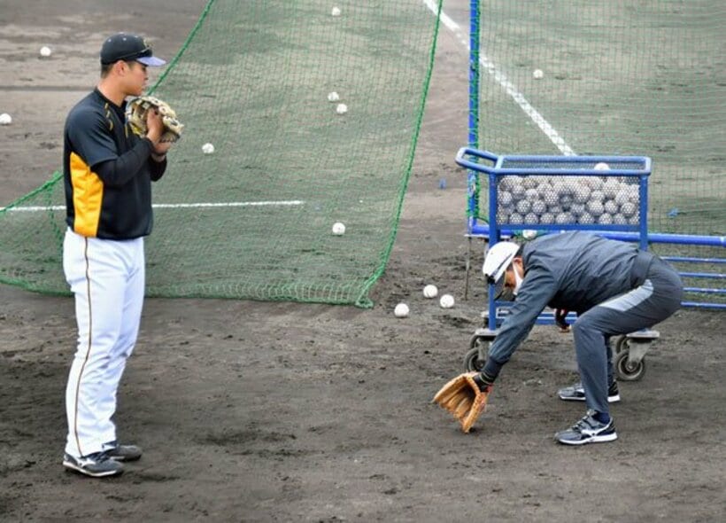  佐藤輝（左）を指導する川相臨時コーチ