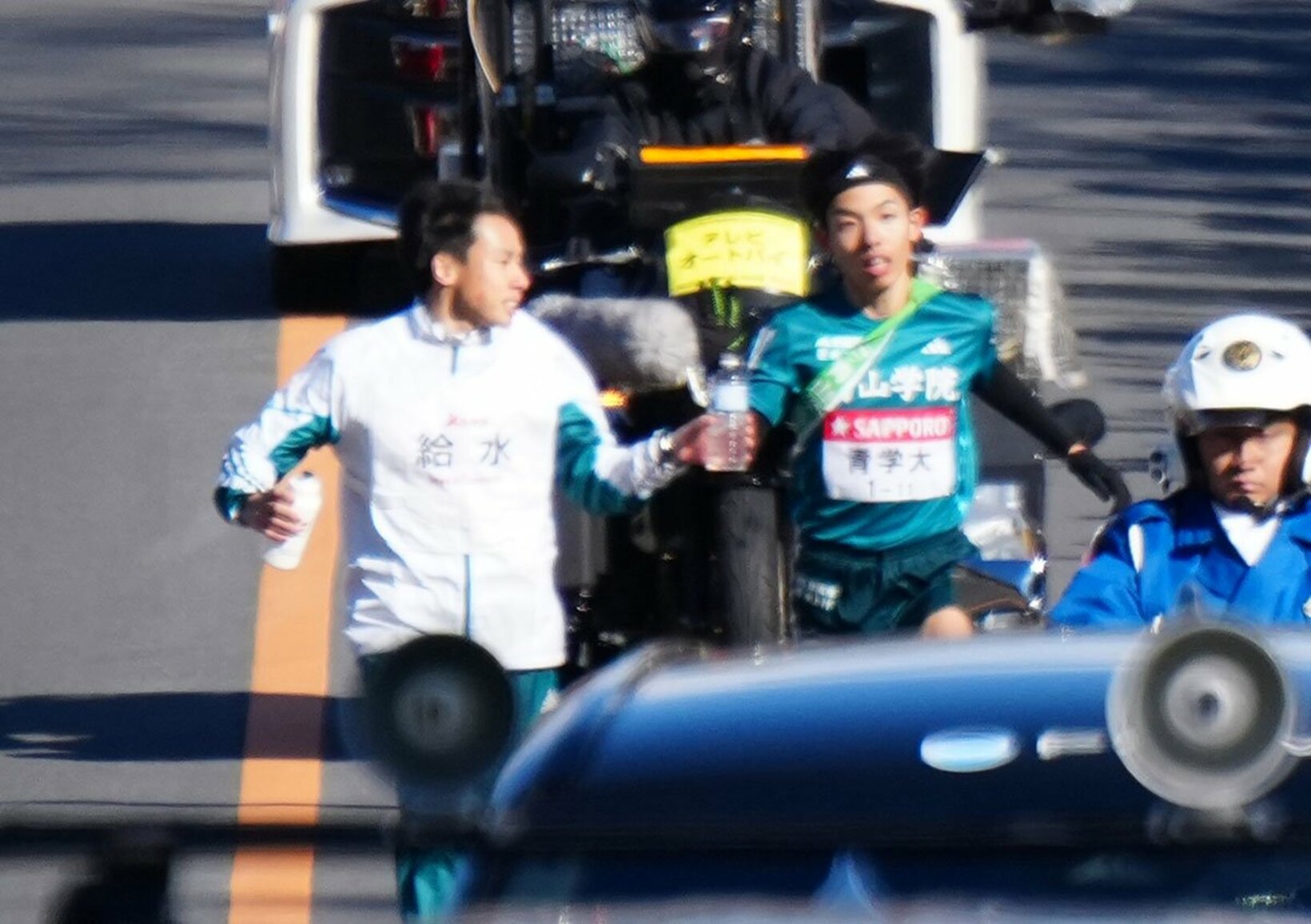 弟の黒田然(左)から水を受け取る青学大・黒田朝日（代表撮影）