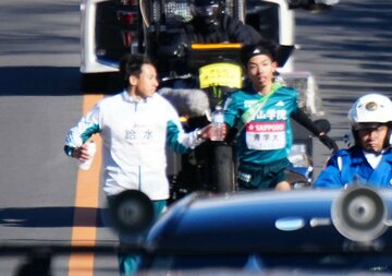弟の黒田然(左)から水を受け取る青学大・黒田朝日（代表撮影）
