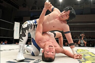 激しい攻防を繰り広げる上野勇希（上）と青木真也