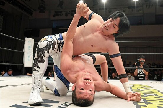 激しい攻防を繰り広げる上野勇希（上）と青木真也