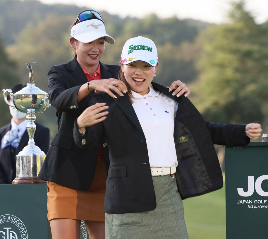  前年の日本女子オープン覇者・原英莉花(左)に優勝ジャケットを着せてもらう勝みなみ