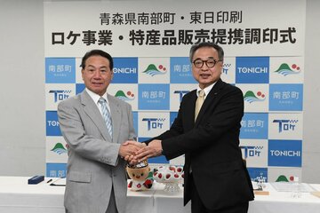 握手を交わす工藤祐直南部町町長（左）と武田芳明東日印刷株式会社社長