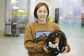 ヘルメットに愛娘と愛犬のイラストを入れている山川波乙