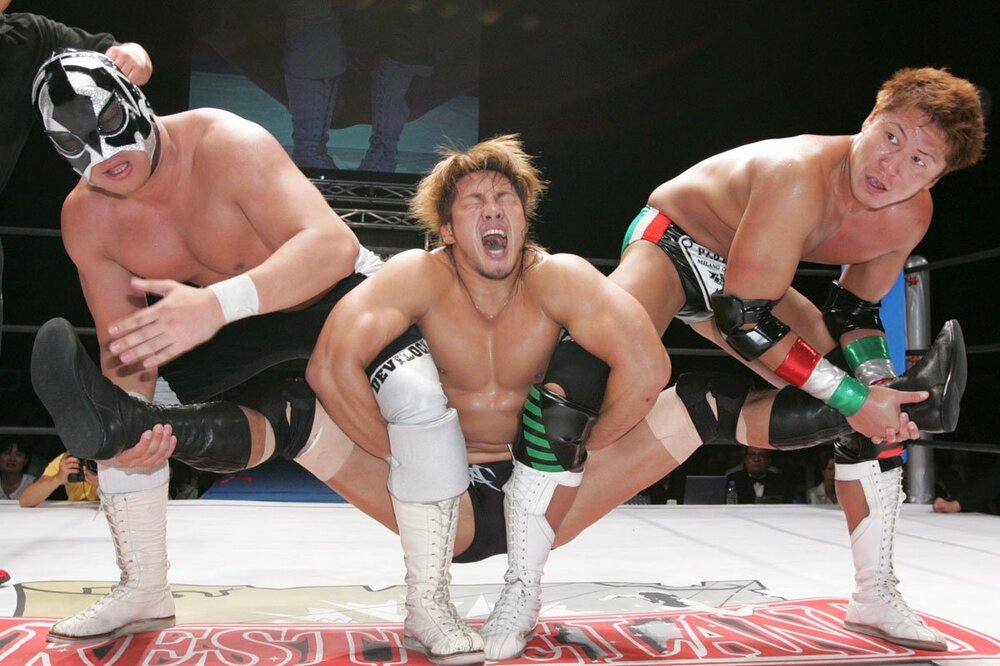 ミラノコレクションA.T.（右）と魔界マスク ド・デビロック（左）から恥ずかし固めを受ける棚橋弘至（写真中、06年7月）