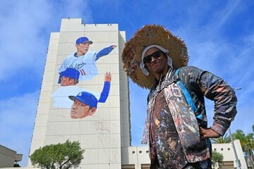 大谷、山本、佐々木の壁画の前でポーズをとる作者のバルガス氏