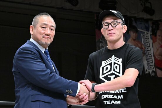 高木三四郎社長（左）と握手する青木真也