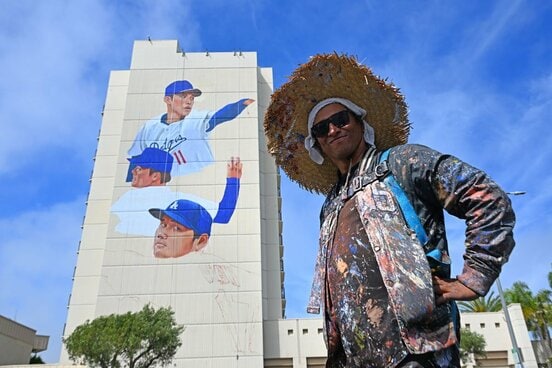 大谷、山本、佐々木の壁画の前でポーズをとる作者のバルガス氏