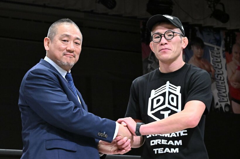 高木三四郎社長（左）と握手する青木真也