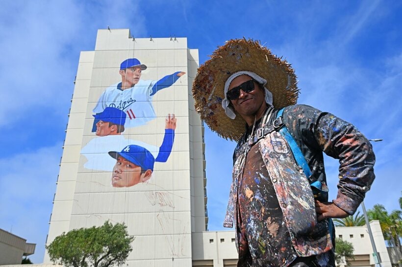 大谷、山本、佐々木の壁画の前でポーズをとる作者のバルガス氏