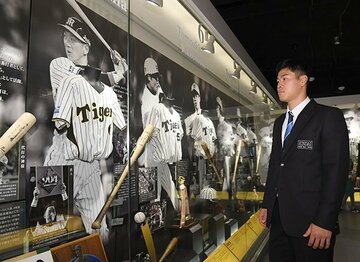  新人施設見学でOBの展示を見る佐藤輝