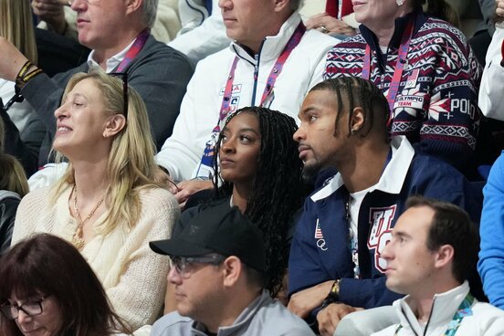 夫でＮＦＬ選手のジョナサン・オーウェンズ(右)とミラノ五輪を観戦中の体操シモーネ・バイルズ（ロイター）