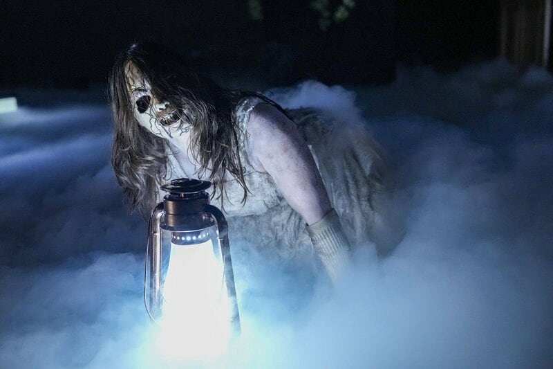 ランタンとともに現れた奇怪な女性。アンクル・ハウディ―の仲間だ（©WWE）