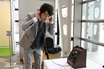 鉱石ラジオで、現在放送されているＮＨＫのラジオ放送を聞く高瀬耕造アナ