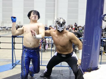  王者デスペラード(右)に鉄柱へと叩きつけられるワト