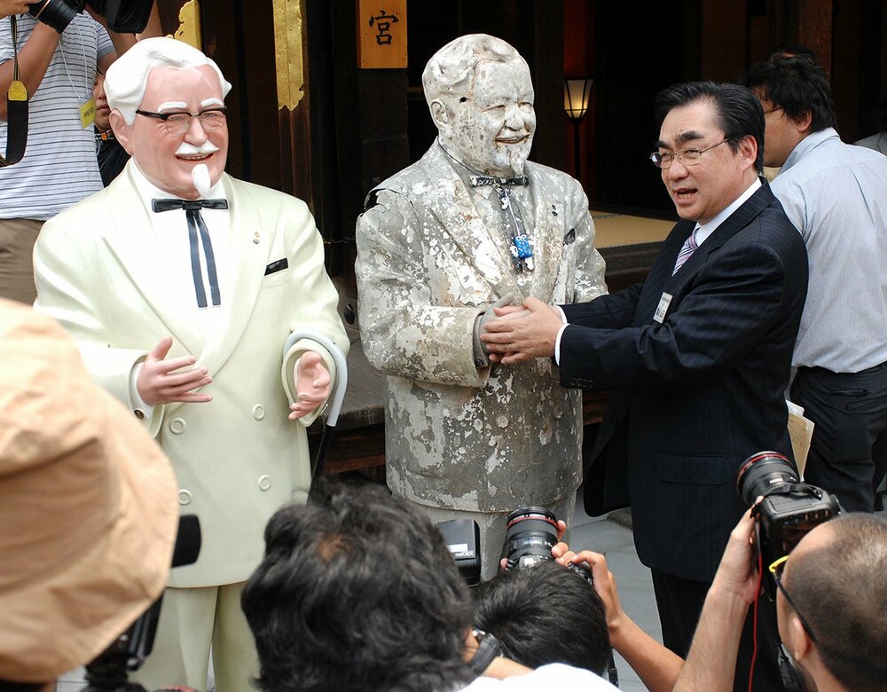 引き揚げられたカーネル像と握手する当時のＫＦＣ社長・渡辺氏（２００９年）