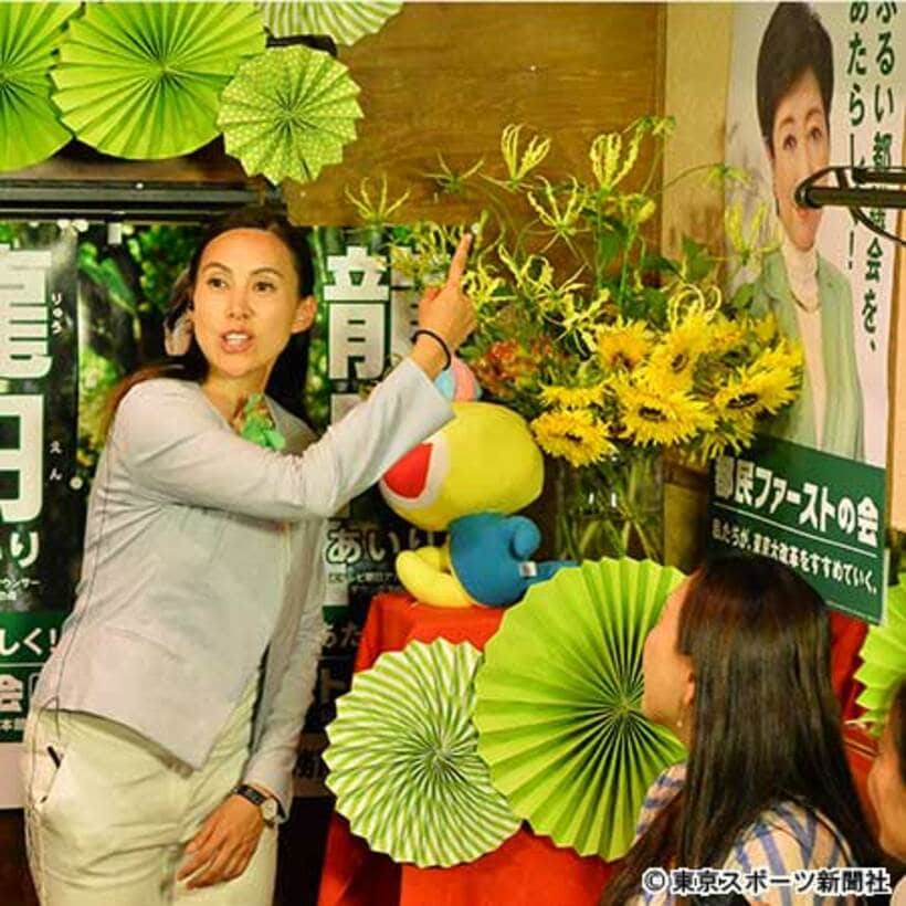 小池氏のポスターを指さして当選を喜ぶ龍円氏