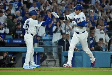 大谷翔平とタッチするディノ・イーベル三塁コーチ(ロイター)