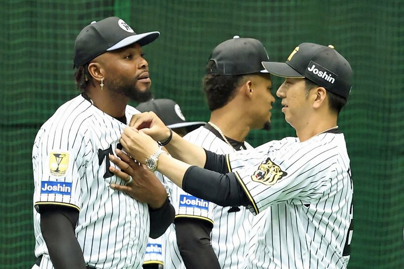 ドリスのユニホームのボタンを留める藤川球児監督