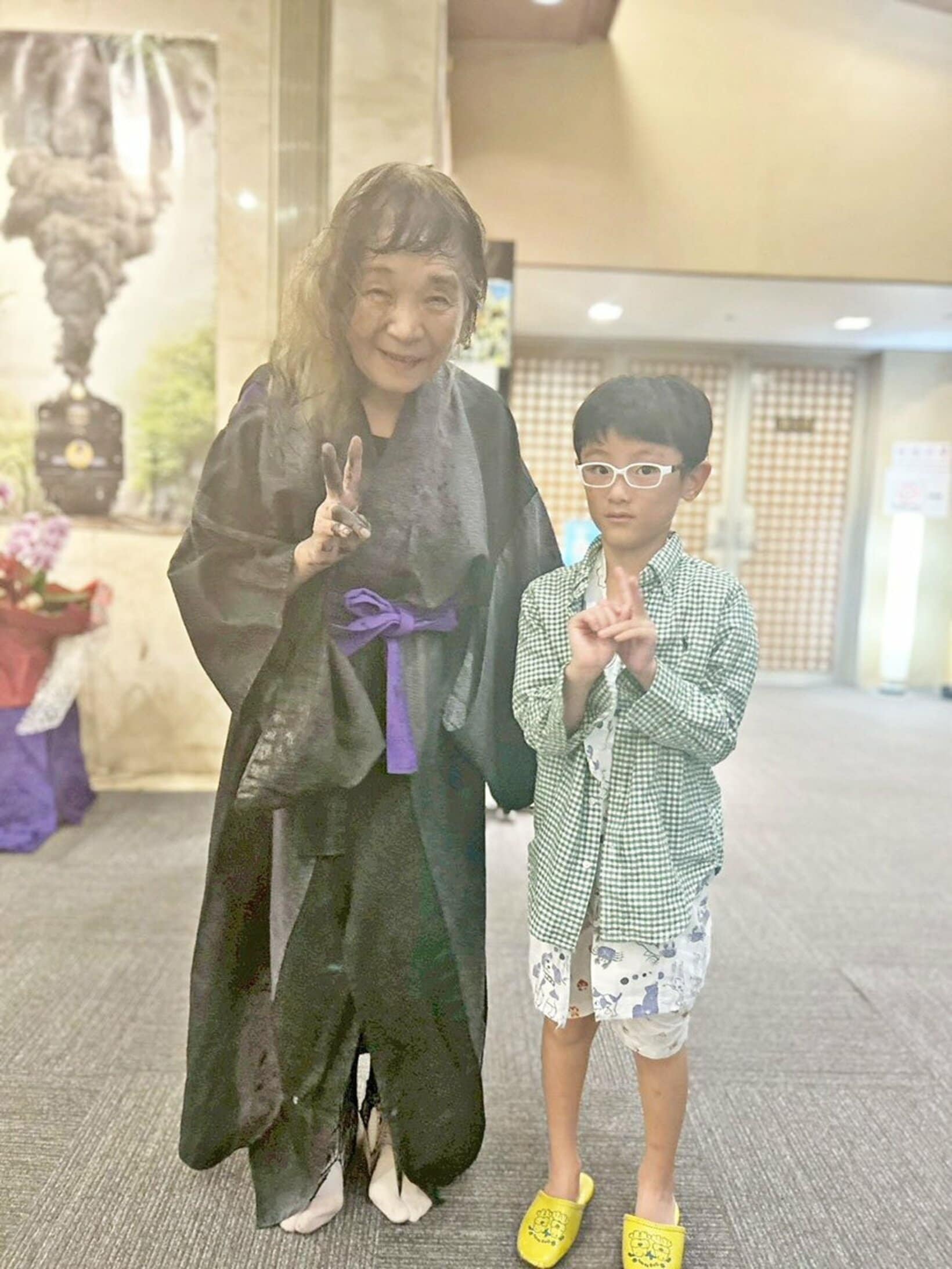 女将(左)と記念撮影した宮崎記者の愛息・達生クン