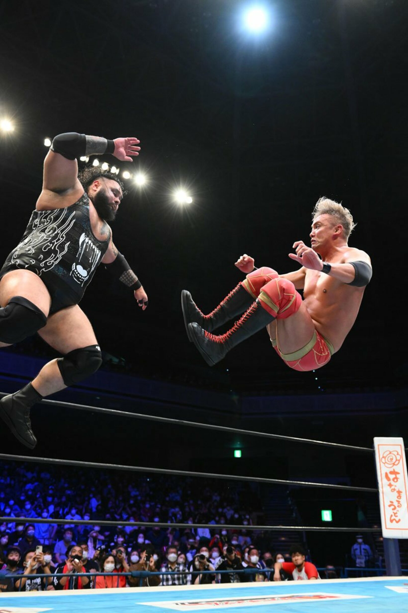 コーナートップから飛んだJONAH（左）をドロップキックで迎撃するオカダ・カズチカ（右）