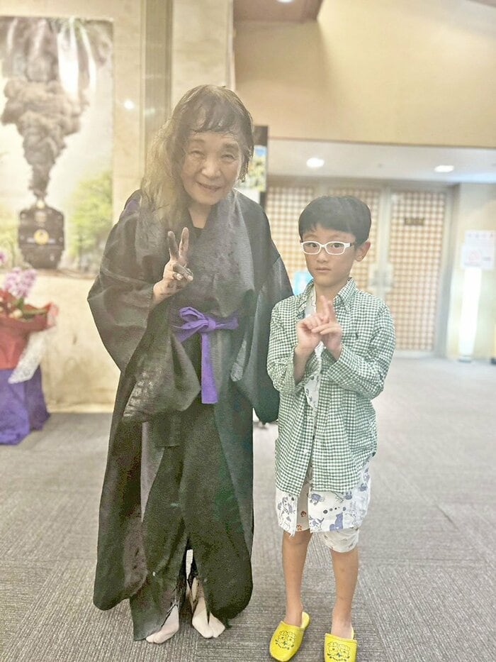 女将(左)と記念撮影した宮崎記者の愛息・達生クン