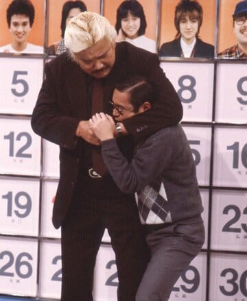 巨漢レスラーにヘッドロックをかけられ悶絶するタモリ