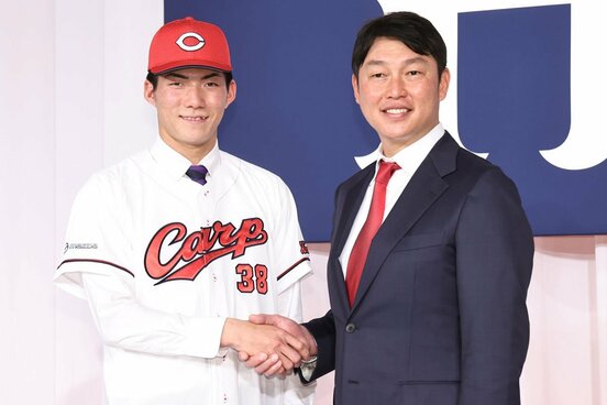 ユニホームに袖を通し、広島・新井監督(右)と握手するドラフト5位・赤木晴哉