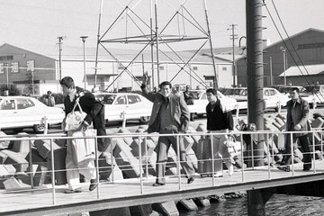 桟橋から手を振る猪木。前を歩くのは前田。猪木の後ろは坂口（右）と付け人の平田（１９７９年１１月、徳島港）