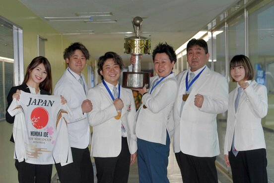 優勝トロフィーを掲げる男子団体選手ら。左から井手広報、畦元、林、村松、小川、ユース代表の井出桃夏