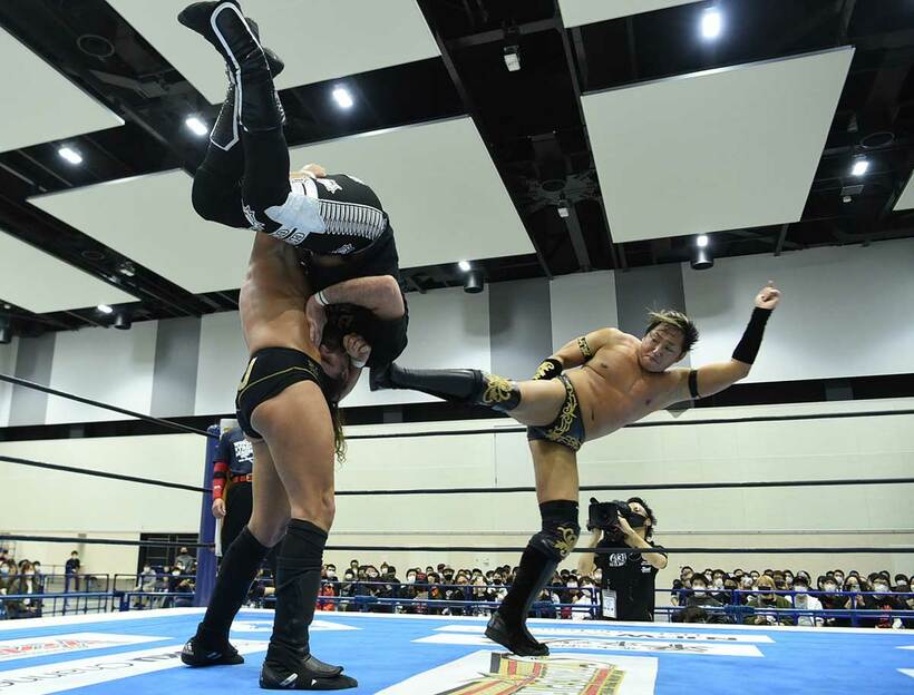  ザックが抱え上げたオーエンズにスーパーキックを打ち込むタイチ（右）