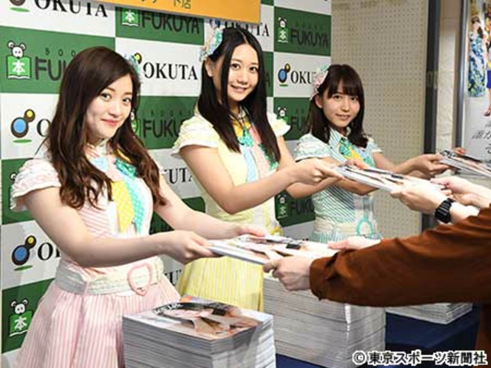 ファンにムック本を手渡しするSKE４８の3人
