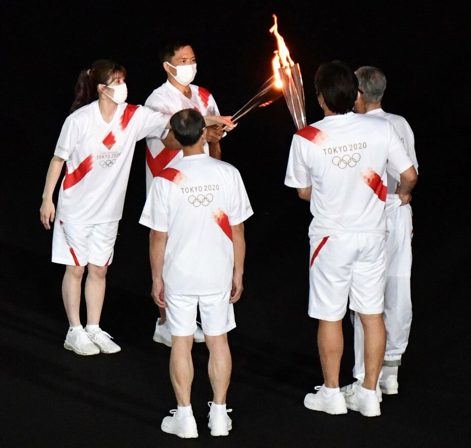  野球のレジェンドトリオに聖火を渡す吉田沙保里（左）
