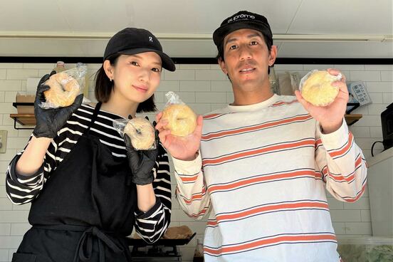 自慢のベーグルを手にする木戸皓貴さん（右）と妻の有佐さん