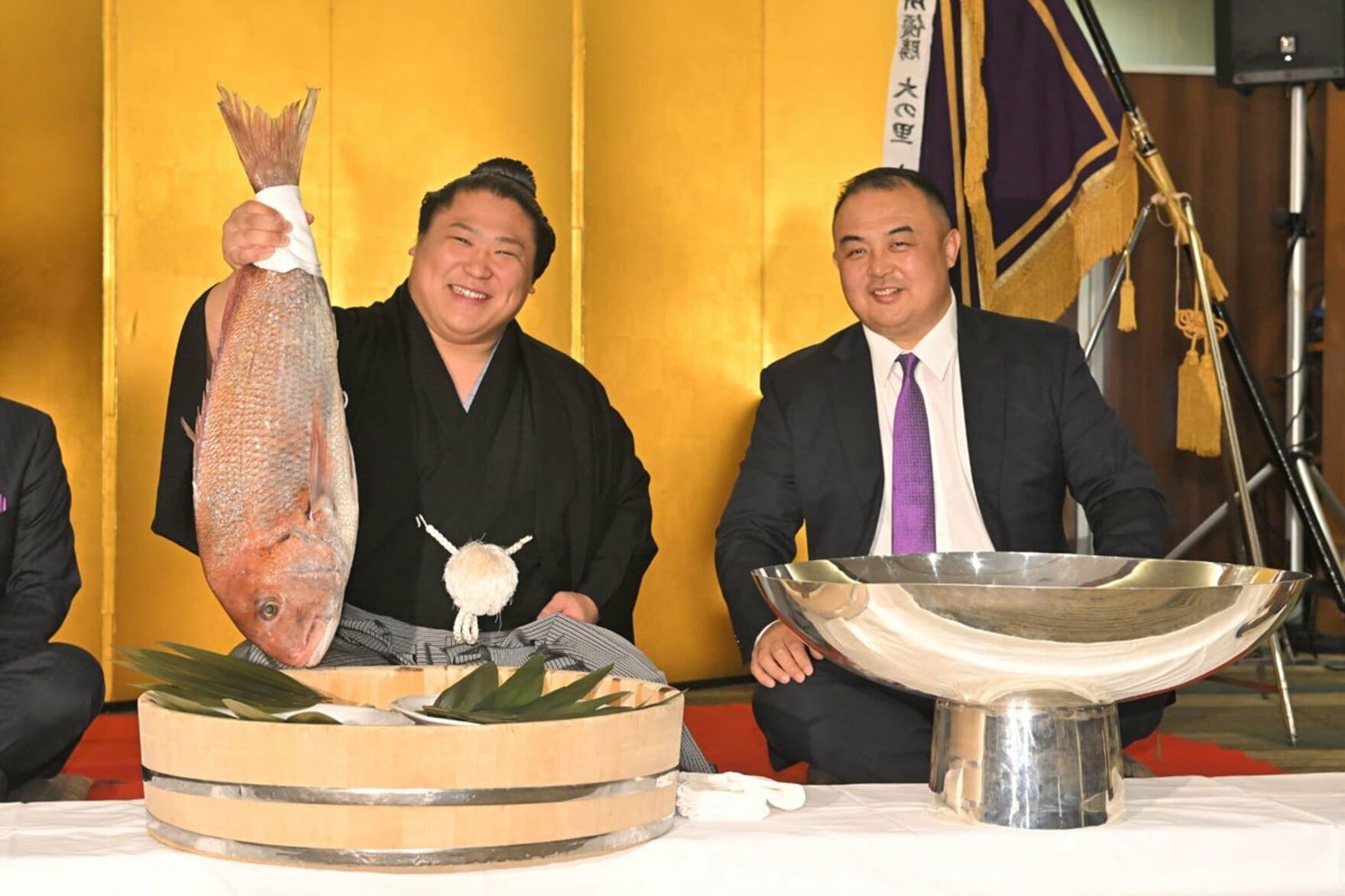 祝勝会で鯛を手に笑顔の若隆景(左)。右は荒汐親方